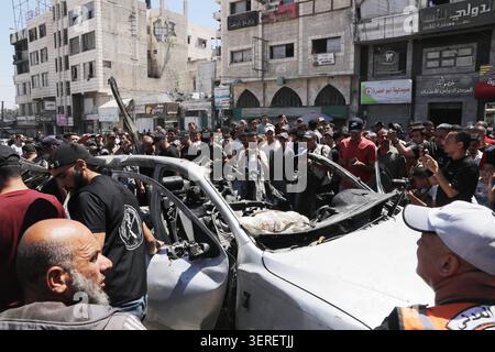 Les Palestiniens se rassemblent sur le site de la grève meurtrière de véhicules dans la ville de Gaza les Palestiniens et le personnel de la défense civile se rassemblent autour d’un véhicule détruit qui a été pris pour cible lors d’une frappe aérienne israélienne dans la ville de Gaza, le 18 juin 2026. La frappe a tué trois Palestiniens, selon des sources médicales, et a causé d'importants dégâts au véhicule. Photo de Belal Osama apaimages Gaza bande de Gaza territoire palestinien 180626 Gaza BO 1 0044 Copyright : xapaimagesxBelalxOsamaxxapaimagesx Banque D'Images