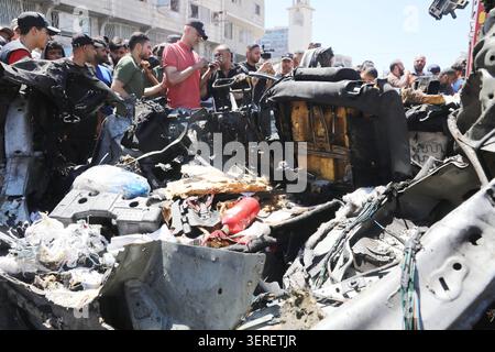 Les Palestiniens se rassemblent sur le site de la grève meurtrière de véhicules dans la ville de Gaza les Palestiniens et le personnel de la défense civile se rassemblent autour d’un véhicule détruit qui a été pris pour cible lors d’une frappe aérienne israélienne dans la ville de Gaza, le 18 juin 2026. La frappe a tué trois Palestiniens, selon des sources médicales, et a causé d'importants dégâts au véhicule. Photo de Belal Osama apaimages Gaza bande de Gaza territoire palestinien 180626 Gaza BO 1 0043 Copyright : xapaimagesxBelalxOsamaxxapaimagesx Banque D'Images