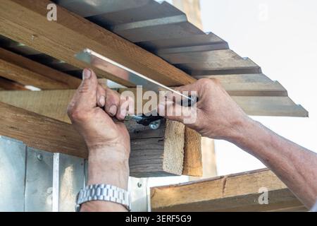 Le constructeur installe la structure de toit en métal de près Banque D'Images