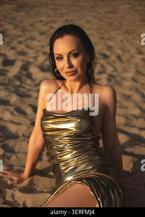 Belle femme dans une robe élégante près du lac au coucher du soleil Banque D'Images