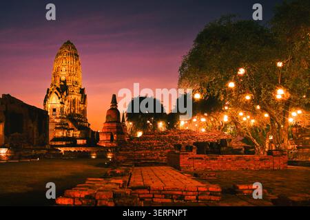 Temple antique de Wat Ratchaburana dans le parc historique d'Ayutthaya, en Thaïlande. Imposant prang central et ruines de briques en ruines illuminées par Li doré chaud Banque D'Images