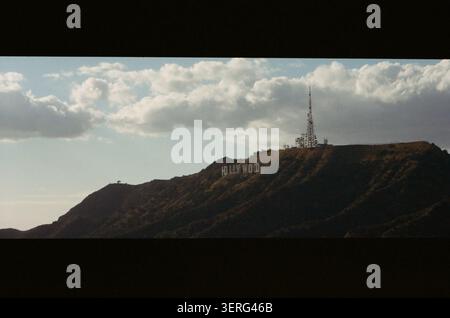 Vue panoramique de style cinéma vintage de l'emblématique panneau Hollywood sur une colline accidentée sous des nuages spectaculaires. Moody, ambiance cinématographique avec vigne sombre Banque D'Images