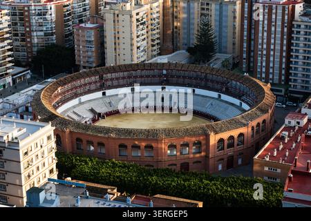 Vue aérienne élevée des arènes historiques de la Malagueta entourées de gratte-ciel et de la mer Méditerranée à Malaga, Espagne. Banque D'Images