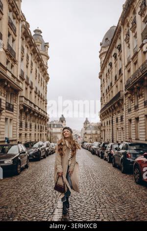 Femme élégante marchant dans une rue pavée à Paris, France Banque D'Images