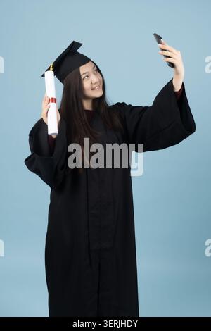 Femme dans une robe de graduation dans un studio Banque D'Images