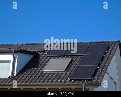 plusieurs modules photovoltaïques sur le toit de la maison fraîchement rénové montrant une modernisation durable réussie sous le ciel bleu Banque D'Images