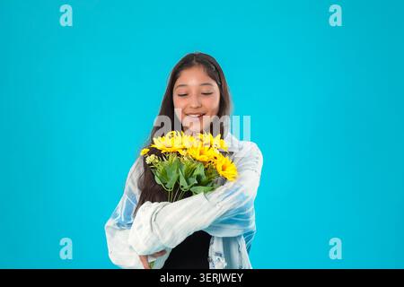 Jeune femme tenant un bouquet de fleurs en studio Banque D'Images