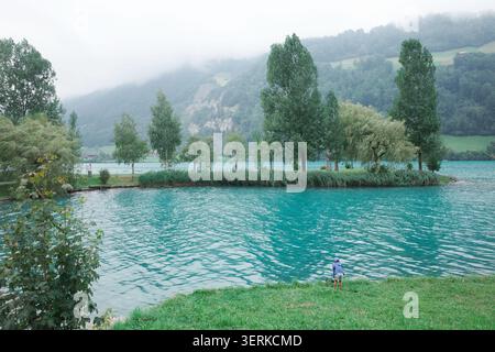 Les superbes eaux turquoises du lac Lungern dans les Alpes suisses sont encadrées par des montagnes brumeuses et une végétation luxuriante Banque D'Images