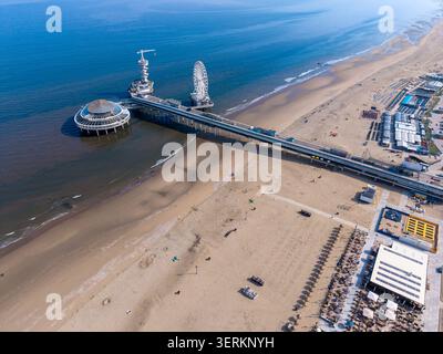 Perspective de drone à angle élevé capturant l'emblématique jetée de Scheveningen qui s'étend dans la mer du Nord bleu profond à la Haye, aux pays-Bas. Le tir sh Banque D'Images