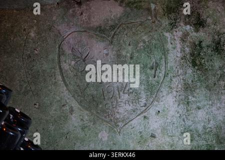 Reims, France - 8 mars 25 : vue rapprochée d'un coeur sculpté et d'une inscription de 1914 sur un mur de cave au Champagne Taittinger à Reims, France. Banque D'Images