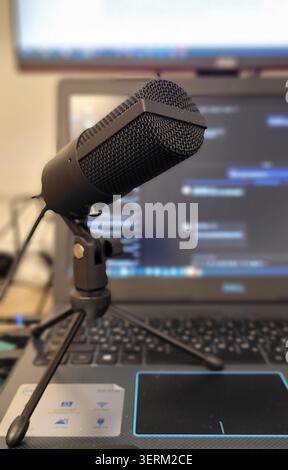 Un microphone professionnel avec filtres pop est installé devant un ordinateur portable. La configuration suggère de se concentrer sur l'enregistrement audio, éventuellement pour des tâches Banque D'Images