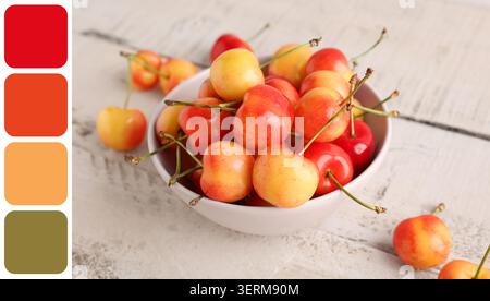 Cerises fraîches rainier dans un bol blanc sur une table en bois rustique, collation de fruits d'été saine, produits biologiques sucrés Banque D'Images