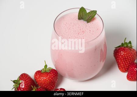 Milkshake aux fraises avec des fraises fraîches sur fond blanc Banque D'Images