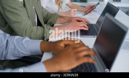 Gros plan vue rognée trois collègues d'affaires de diversité travaillant en tapant des ordinateurs portables dans le bureau méconnaissable équipe hommes d'affaires travail ordinateurs femme d'affaires Banque D'Images