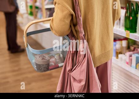 Femme méconnaissable transportant des produits de beauté pendant le magasinage en magasin Banque D'Images