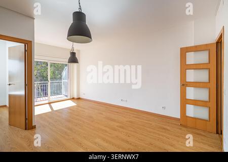 Pièce vide avec parquet, grande fenêtre et suspension moderne. Design intérieur lumineux et spacieux avec style minimaliste. Banque D'Images