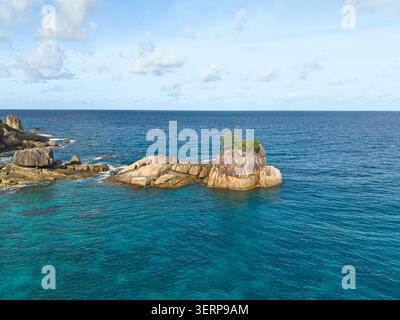 Vue aérienne par drone de la plage d'Anse Solei, mer turquoise et calme et pierres de granit, Mahé Seychelles Banque D'Images