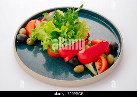 Salade de légumes frais sur une assiette bleue rustique Banque D'Images