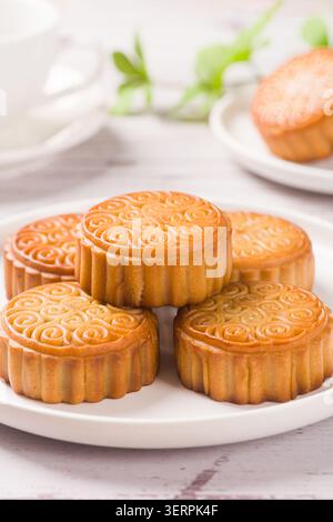 Gâteaux de lune traditionnels aux motifs complexes présentés sur une assiette blanche Banque D'Images