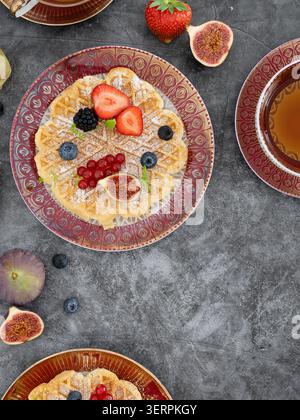 Petit-déjeuner composé de crêpes garnies de fruits frais et servies avec thé Banque D'Images