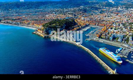 Vue aérienne par drone du Port de Nice Lympia avec le navire à passagers Corsica Ferries amarré au port et la colline de Château derrière, France Banque D'Images