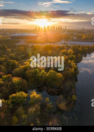 Vue aérienne de Varsovie au coucher du soleil avec le stade national et le feuillage d'automne dans le parc Skaryszewski au bord du lac en Pologne. Banque D'Images
