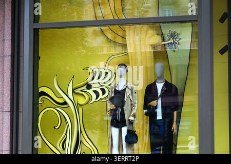Deux mannequins chics affichent des tenues tendance sur un fond jaune vif. Kiev, Ukraine 19 juin 2026 Banque D'Images