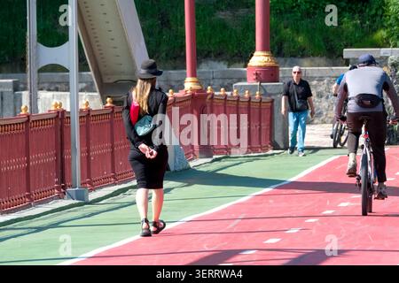 Une femme élégante marche tranquillement le long d'un sentier coloré au bord de l'eau. Kiev, Ukraine 19 juin 2026 Banque D'Images