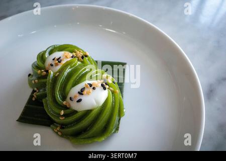 Kue Kaswi Pandan, gâteaux traditionnels du Kalimantan occidental, à base de farine de tapioca et de feuille de pandan, saupoudrés de graines de sésame. Banque D'Images