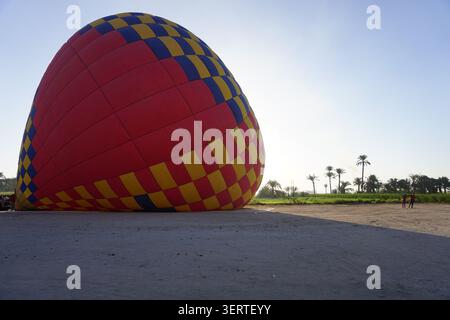 Montgolfière manipulée par l'équipage au sol après une descente près de Louxor, en Égypte Banque D'Images