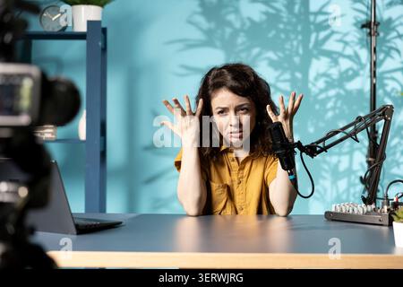 Influenceur se sentant en colère, partageant une histoire concernant les médias sociaux vidéo, parlant aux fans. Le créateur de contenu frustré parle avec les téléspectateurs, ayant une dépression mentale devant les abonnés. Banque D'Images