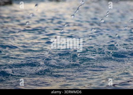 Gouttelettes d'eau éclaboussant sur une surface ondulée Banque D'Images