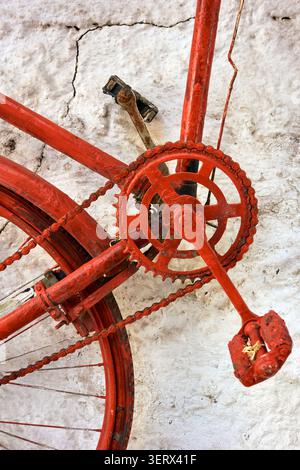 Pédales de vélo rouges contre un mur blanc. Banque D'Images