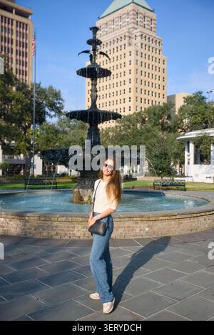 Femme pleine longueur en Jeans posant à City Fountain Park Lifestyle Portrait Banque D'Images