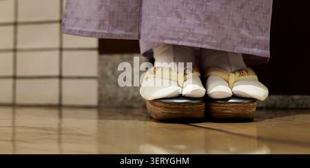 Gros plan des sandales Zori japonaises traditionnelles et des chaussettes Tabi portées avec Kimono Banque D'Images