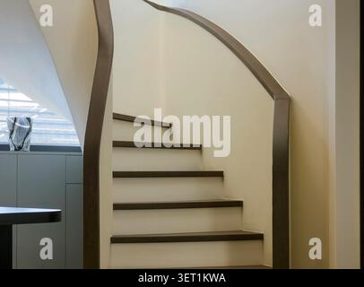 Escalier en bois courbé moderne dans un design intérieur minimaliste Banque D'Images