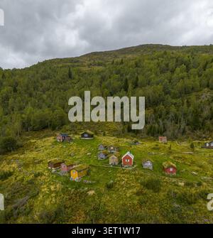 Vue aérienne de la ferme historique de montagne de Rakssetra avec des cabanes traditionnelles en bois au toit d'herbe dispersées sur une colline verdoyante à Stryn Munici Banque D'Images