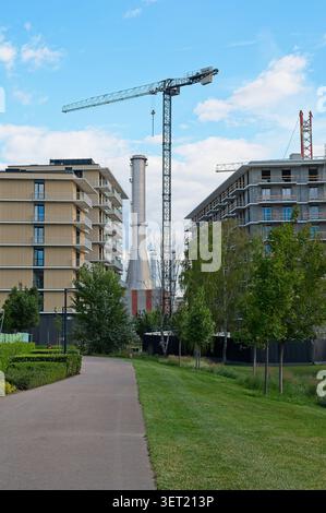 Budapest, Hongrie - 12 juin 2026 : chantier de construction dans le quartier Budapart avec des bâtiments résidentiels modernes, des grues à tour et une cheminée industrielle. Banque D'Images
