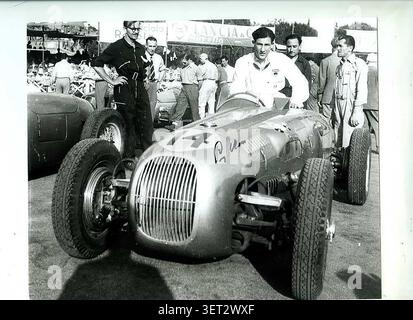Stirling Moss avec une HWM-Alta dans une course en Italie en 1950. L'entrée #14 pourrait avoir été GP Rome le 11 juin 1950, où il a, selon les journaux locaux, l'entrée #14.[1] la source de cette photo (annonce de vente [2]) dit que cette photo est prise à Garda (course F2 le 15 octobre 1950), mais Moss a eu la course #20 à Garda... L'homme en noir ressemble globalement au mécanicien Ray Martin, qui travaillait avec Moss ces années-là. Banque D'Images