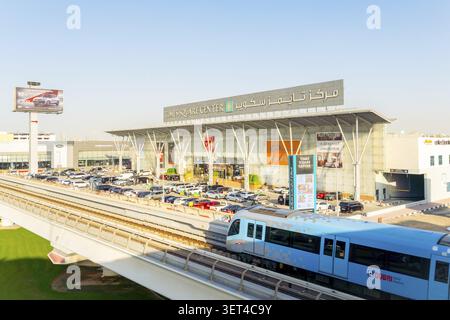 Dubaï, Émirats arabes Unis - 25 octobre 2025 : train moderne sans conducteur sur la voie surélevée du métro de Dubaï. Entrée du centre commercial Dubai Times Square Center, façade vitrée et Banque D'Images