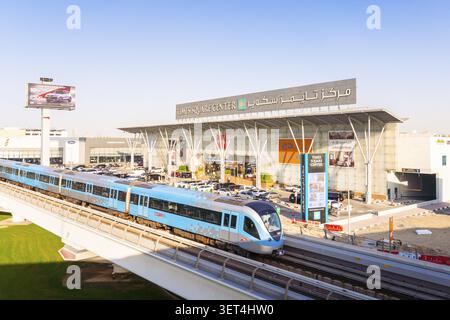 Dubaï, Émirats arabes Unis - 25 octobre 2025 : train moderne sans conducteur sur la voie surélevée du métro de Dubaï. Entrée du centre commercial Dubai Times Square Center, façade vitrée et Banque D'Images