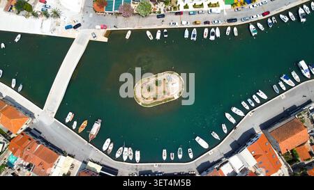 Vue aérienne montrant l'entrée du port de vrboska et le canal avec de nombreux bateaux amarrés, pont, et une petite île verte Banque D'Images