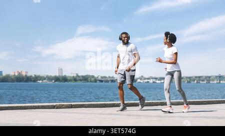 L'homme et de la Femme positive le long de River Embankment Banque D'Images