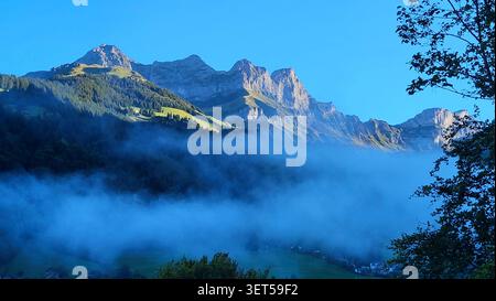 Lever de soleil alpin mystique avec brume matinale dans les Alpes d'Engelberg Suisse Banque D'Images