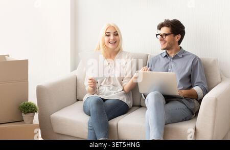 Couple profite de temps de qualité tout en planifiant leur nouvelle vie ensemble dans un salon confortable Banque D'Images