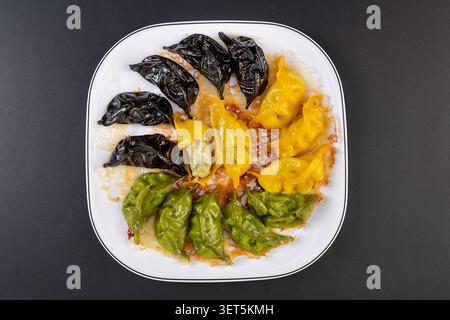Potstickers croustillants, boulettes colorées de Gyoza poêlées sur fond noir Banque D'Images