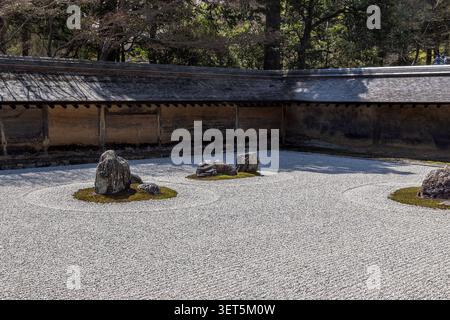 Groupes de pierres et gravier ratissé dans le célèbre jardin karesansui du temple Ryoanji à Kyoto, Japon. Banque D'Images