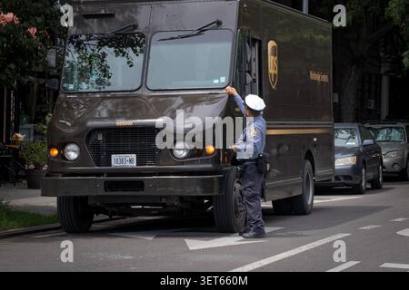 Un policier de la police de NYPD dans la division de la circulation des billets pour un camion UPS stationné illégalement. À Jackson Heights, Queens, New York. Banque D'Images