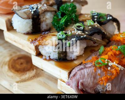 Set de sushis d'anguille et sushis de bœuf brûlé sur un plateau en bois dans un restaurant japonais. Cuisine japonaise. Banque D'Images