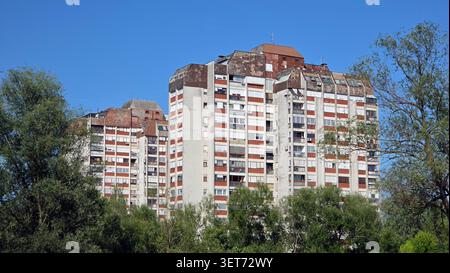 Une vue grand angle montrant un complexe massif de gratte-ciel d'appartements en béton vieilli et en briques avec des toits altérés distinctifs s'élevant au-dessus d'un dense Banque D'Images